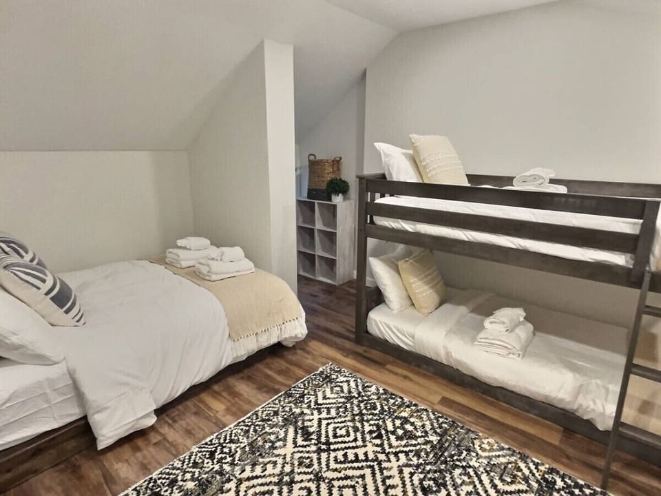 A spacious bedroom designed, featuring a luxurious double bed flanked by two charming bunk beds.
