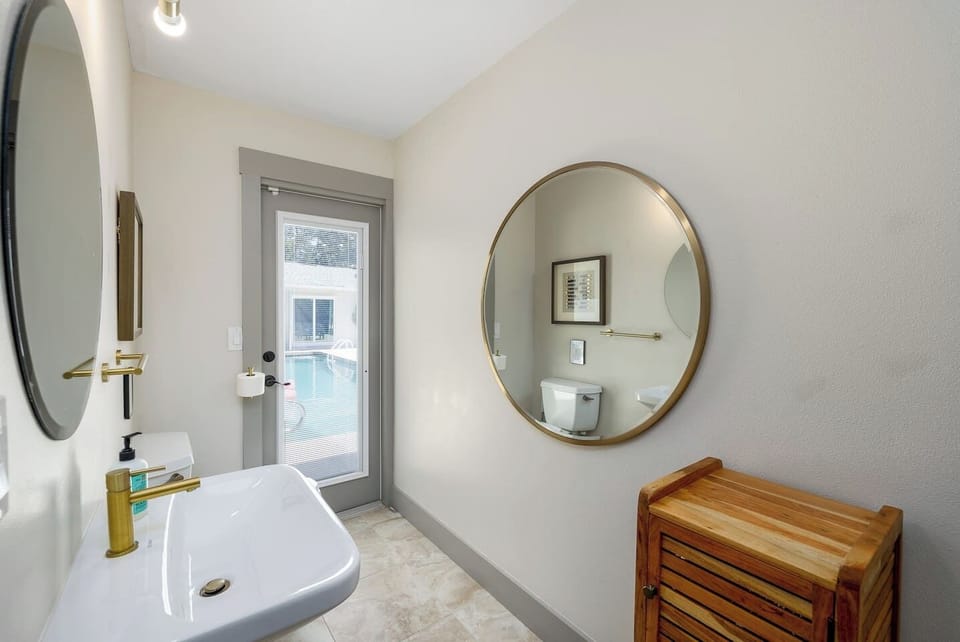 Main house half bathroom with door leading to pool 