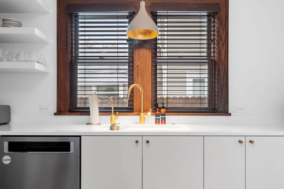 Your sleek kitchen features modern appliances, elegant pendant lighting, and a beautiful window view for cooking inspiration.