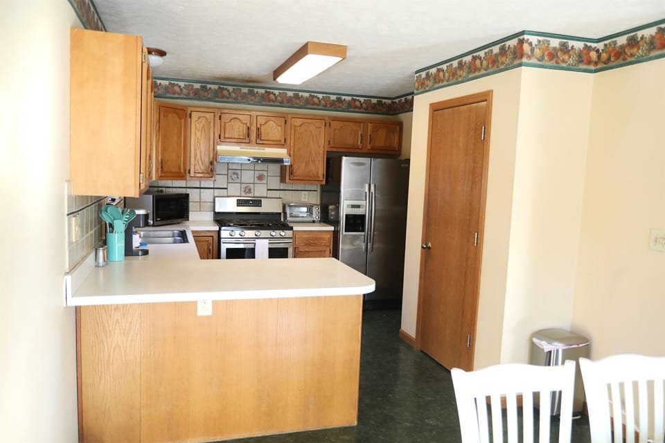 Kitchen showing Keurig, sink, microwave, stove, toaster oven, fridge, and pantry, dishwasher is in front of the Keurig