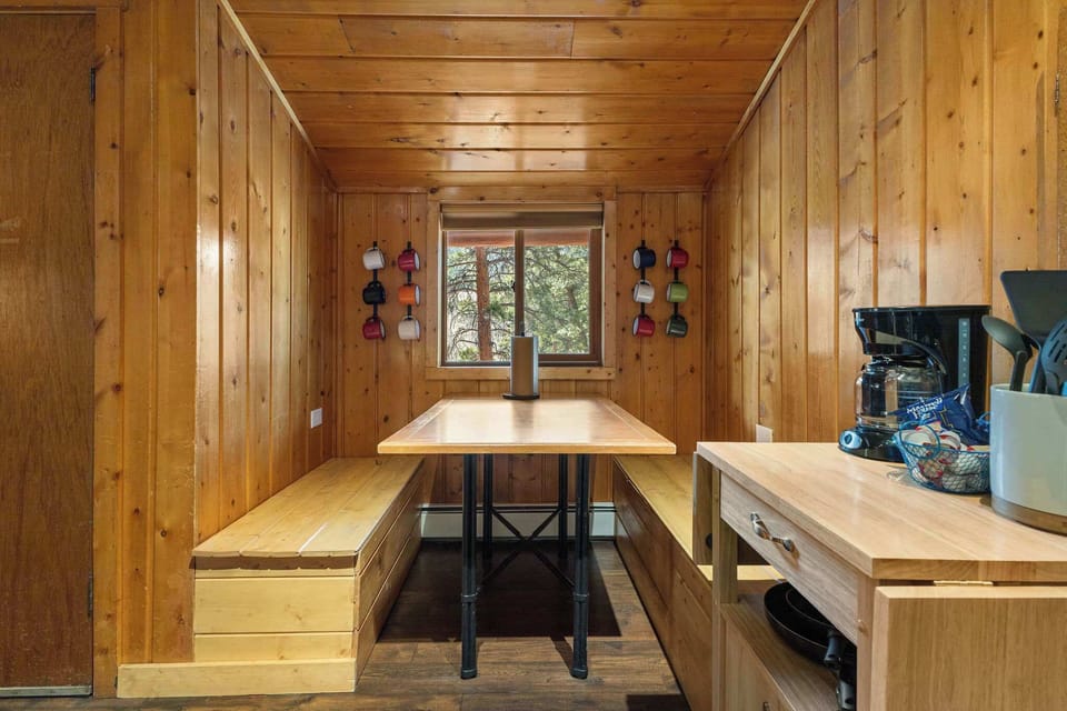 There is a dining table with built in benches by the window.