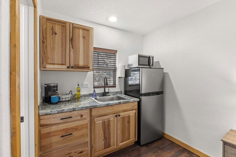 The kitchen has plates, bowls, cups, silverware and pots for the hot plate.