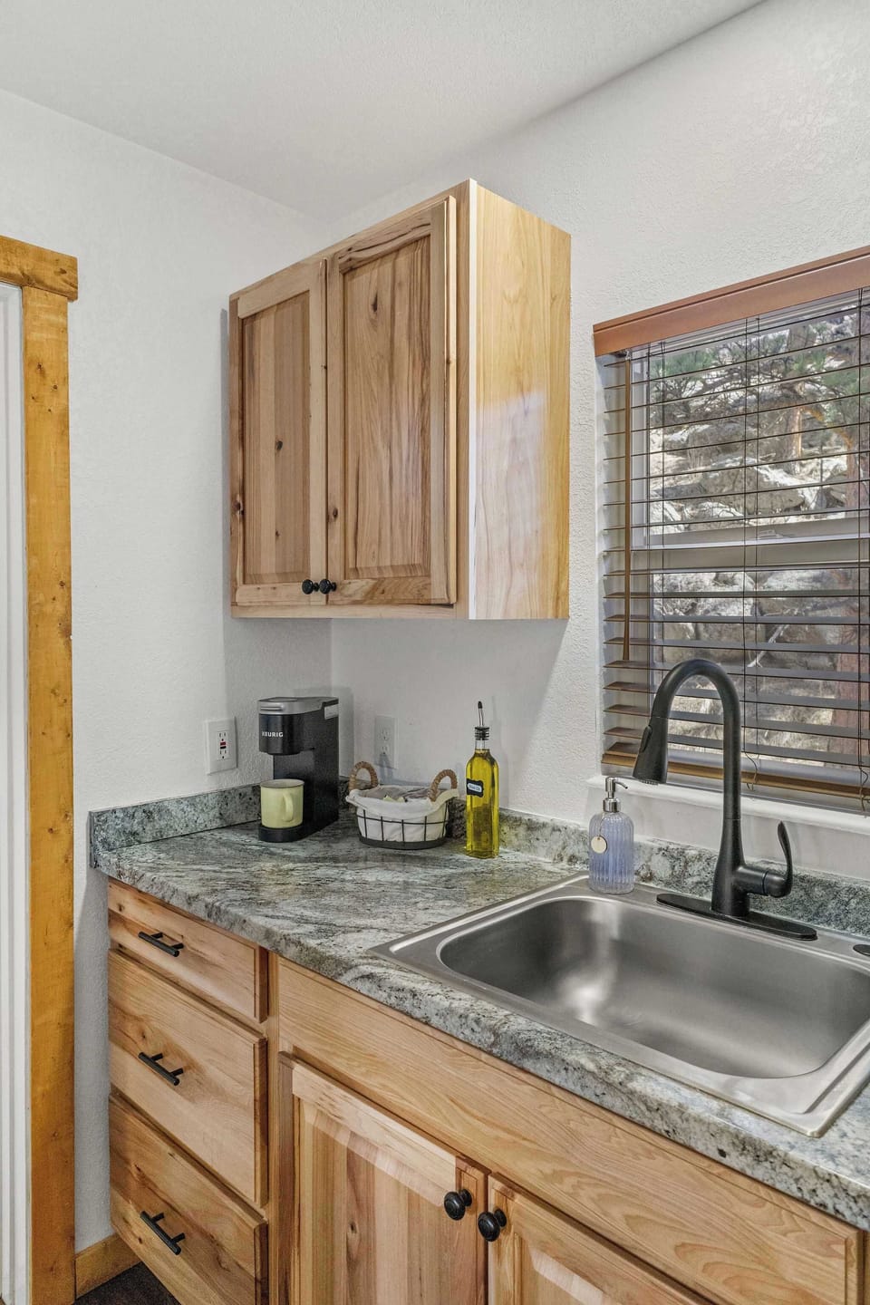 The kitchen has dishes, silverware, cups, coffee mugs and pots to use on the hot plate.