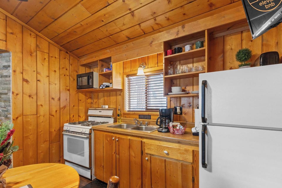 The kitchen is stocked with dishes, cookware and coffee, cream and sugar!