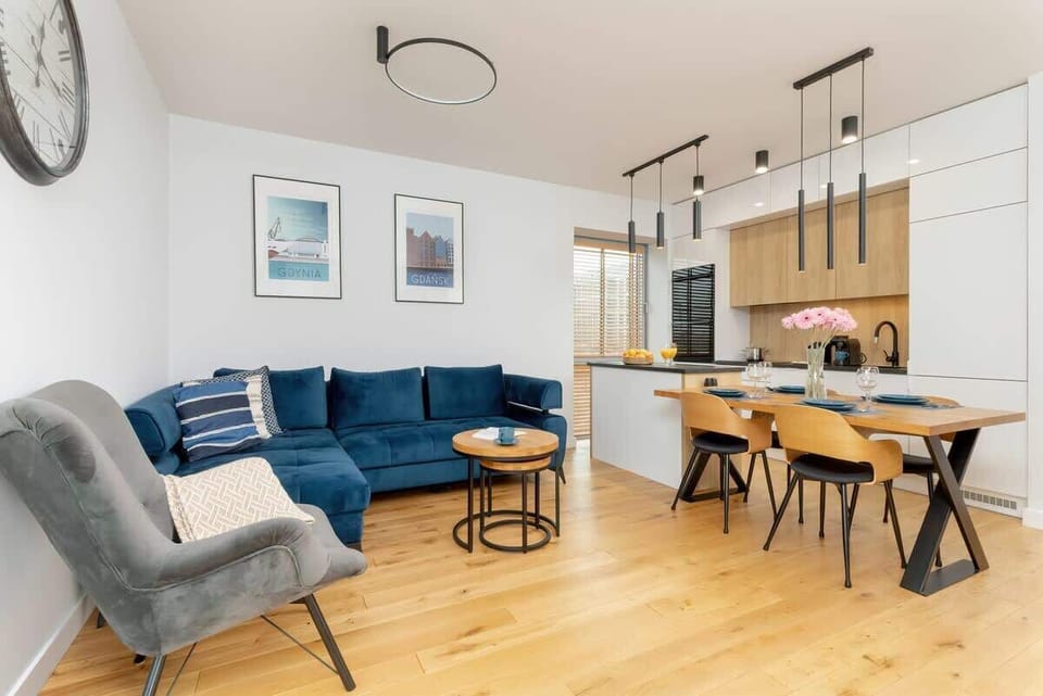 Another angle of the living room showcasing the blue sofa, sleek furniture, and minimalist decor.
