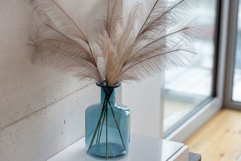 Stylish vase with dried pampas grass, placed on a bright windowsill for a natural touch.
