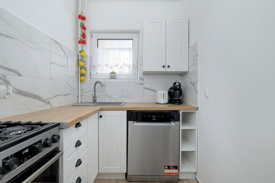 The kitchen is equipped with kitchen utensils and a dishwasher.