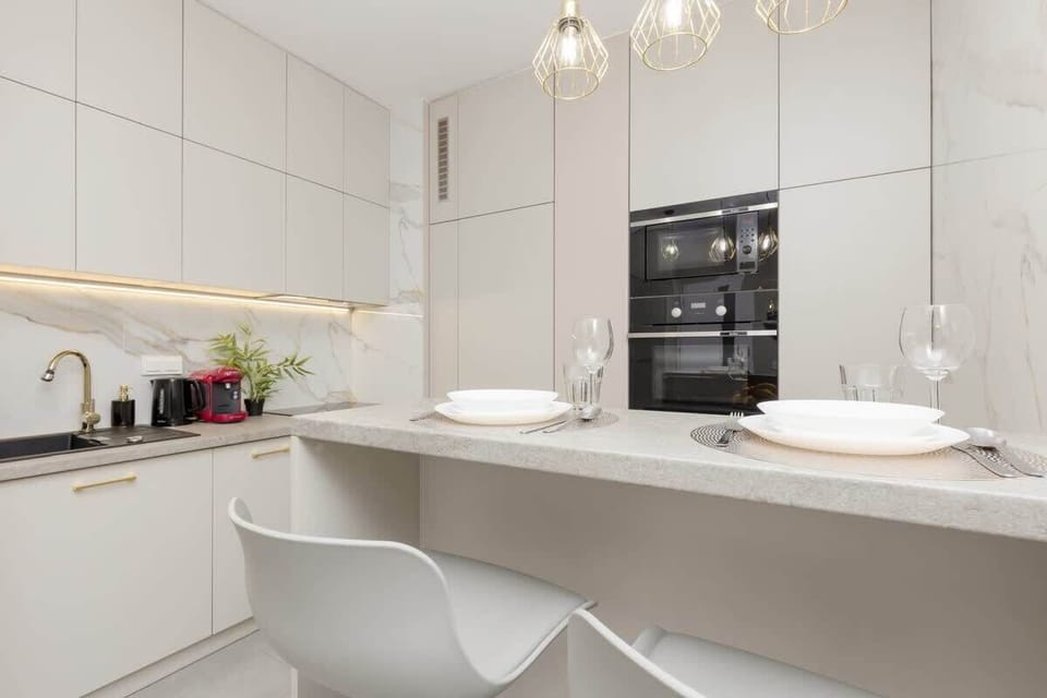 Open-plan kitchen and dining area with a stylish island, modern appliances, and soft pendant lighting.
