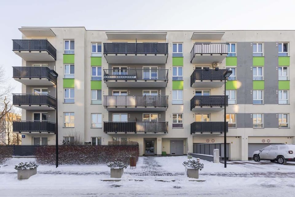 Exterior view of the contemporary residential building with balconies and snowy surroundings.

