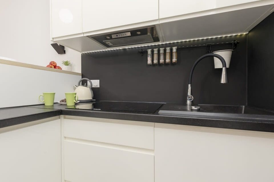 Sleek black kitchen sink with modern fixtures and a neatly organized workspace.
