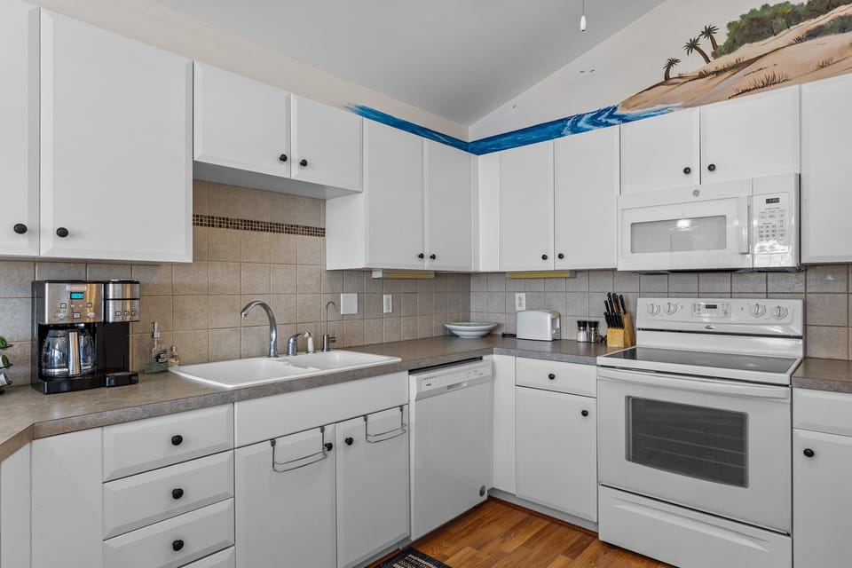 Your fully equipped kitchen features white cabinets, granite counters, and modern appliances—everything you need to create memorable meals during your stay.