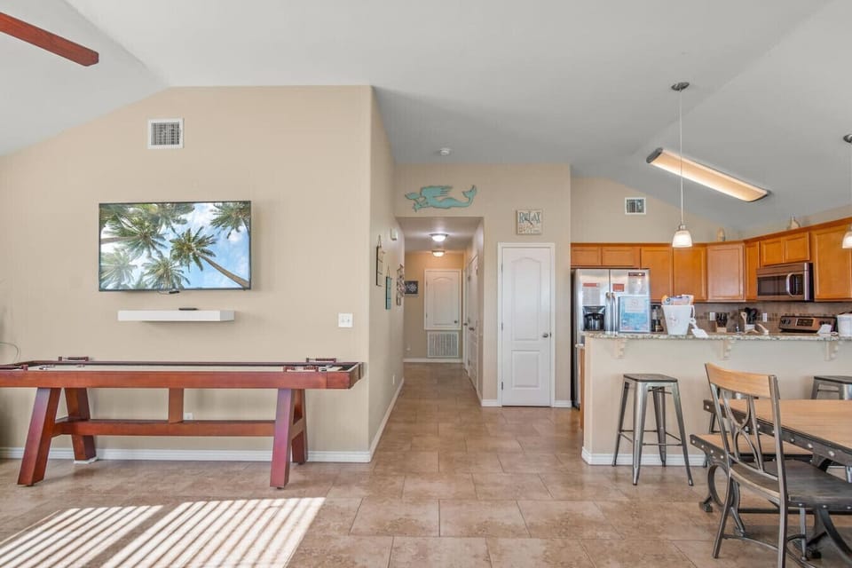Spacious layout with kitchen, dining, and game table all in view.