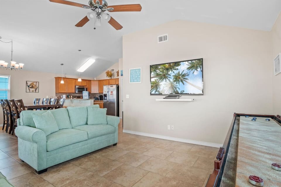 Main living area with sofa seating, TV, and shuffleboard table.