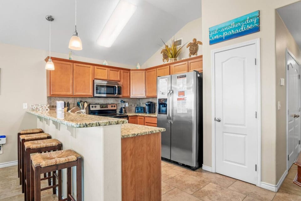 Fully equipped kitchen with breakfast bar seating.