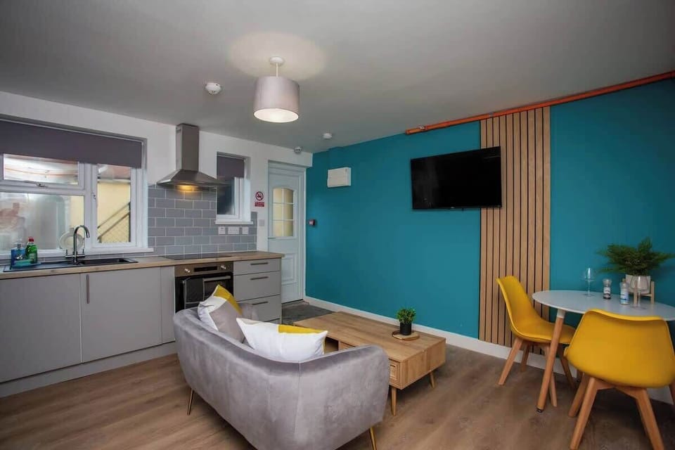 Living room with a state-of-the-art kitchen to assist in culinary endeavors, while a sleek heat extractor ensures a fresh and airy atmosphere as you cook up a storm