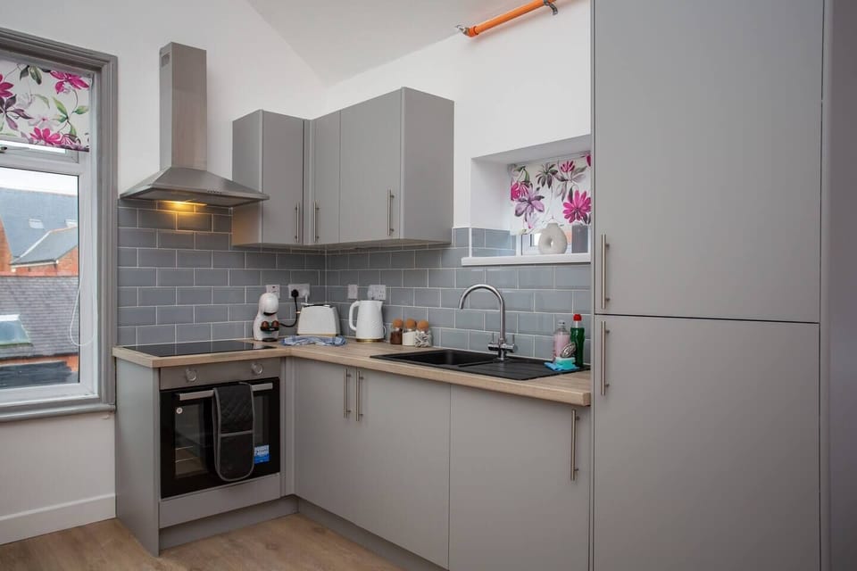 Gleaming countertops and stainless steel appliances create a chef's paradise, while a stylish heat extractor ensures a fresh and airy atmosphere as you cook up a storm.
