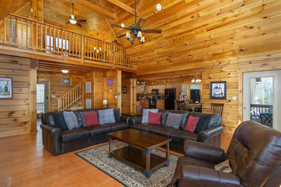 Living room with gas logs fireplace, 51" Smart TV (cable and streaming), and deck access
