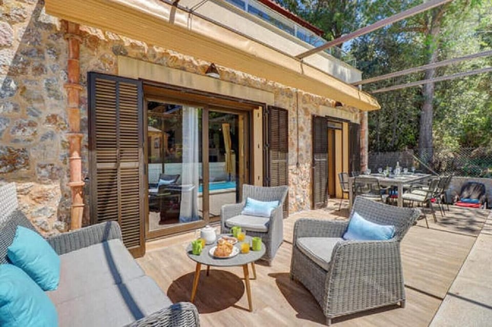 Outdoor chill-out area at Villa Gabriela in Mal Pas – Bonaire, featuring comfortable sofas, a breakfast table and direct access to the private pool, perfect for relaxing outdoors in Mallorca.