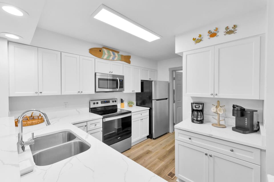 Fully stocked kitchen with stainless steel appliances.
