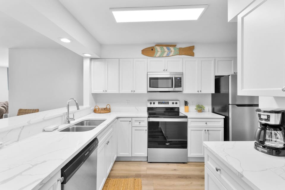 Fully stocked kitchen with stainless steel appliances.