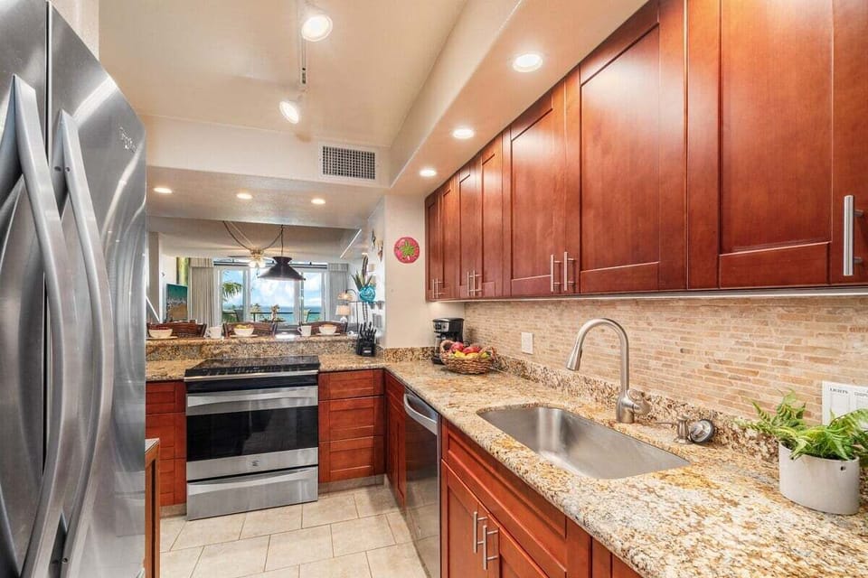 Modern kitchen featuring stainless steel appliances, granite countertops, and wooden cabinetry