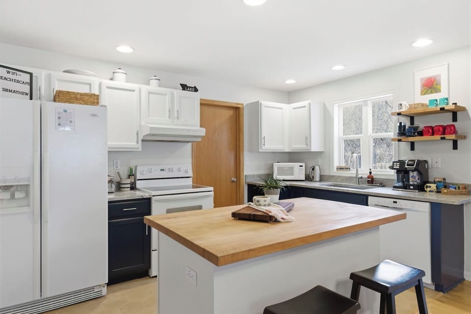 Freshly updated kitchen area with white cabinets and quartz countertop
