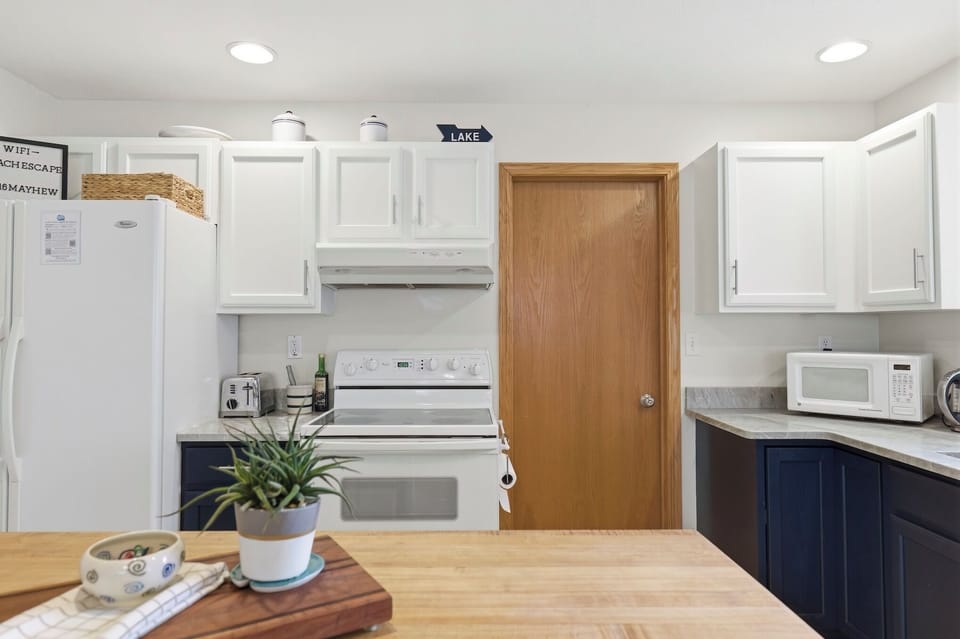 Enjoy a bright kitchen featuring white cabinetry and new quartz countertops