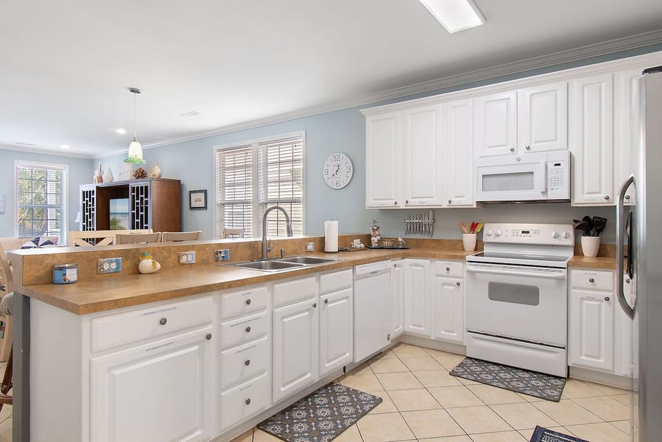 Your fully equipped kitchen welcomes you with gleaming white cabinets, warm wood countertops, and all the appliances you need for home cooking.