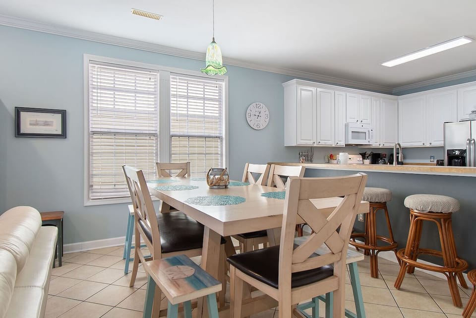 Gather around your bright dining space where coastal charm meets modern comfort, perfect for sharing memorable meals together.