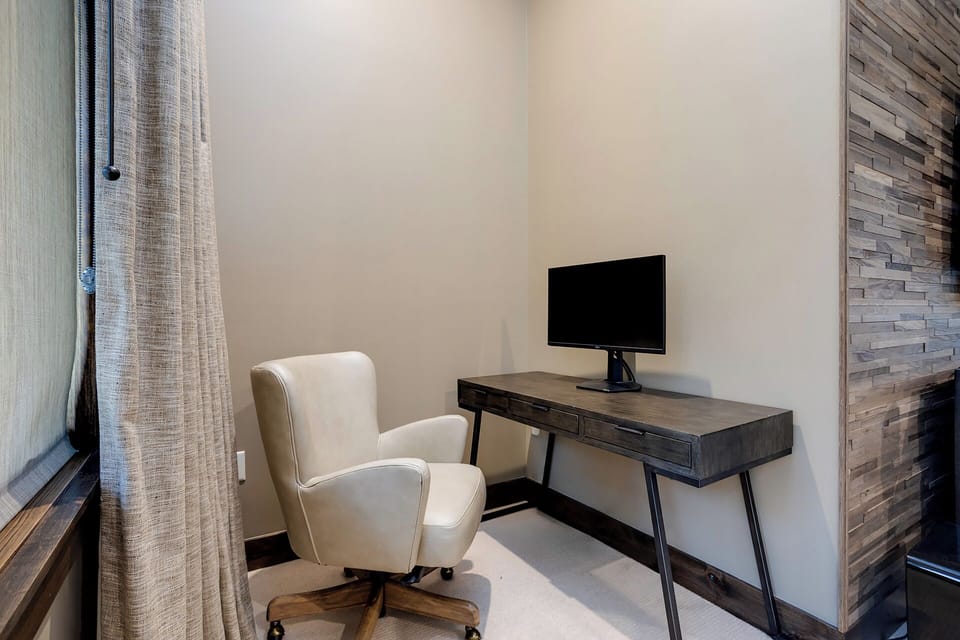 Your private workspace awaits with a stylish desk, comfortable chair, and modern monitor—perfect for productive mornings or catching up.