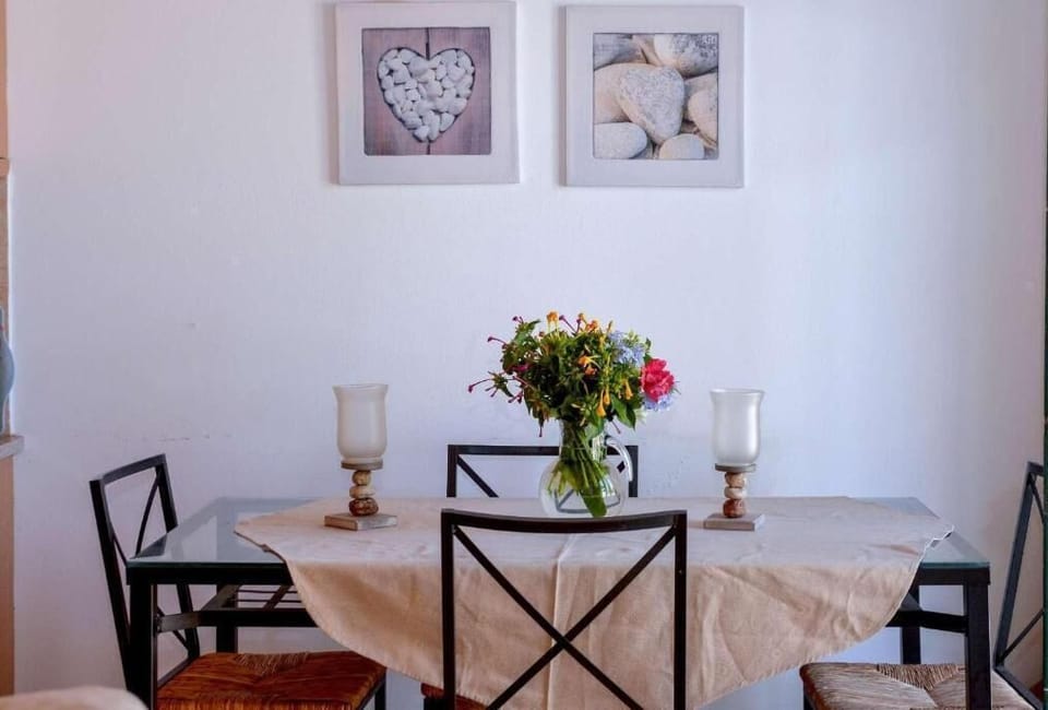 Open-plan living room with sofas, dining area, kitchen, A/C, WiFi internet, and satellite TV