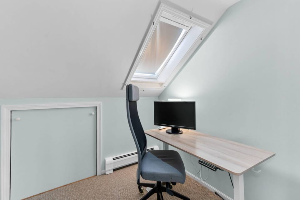 Office with motorized sit/stand desk and 23" monitor