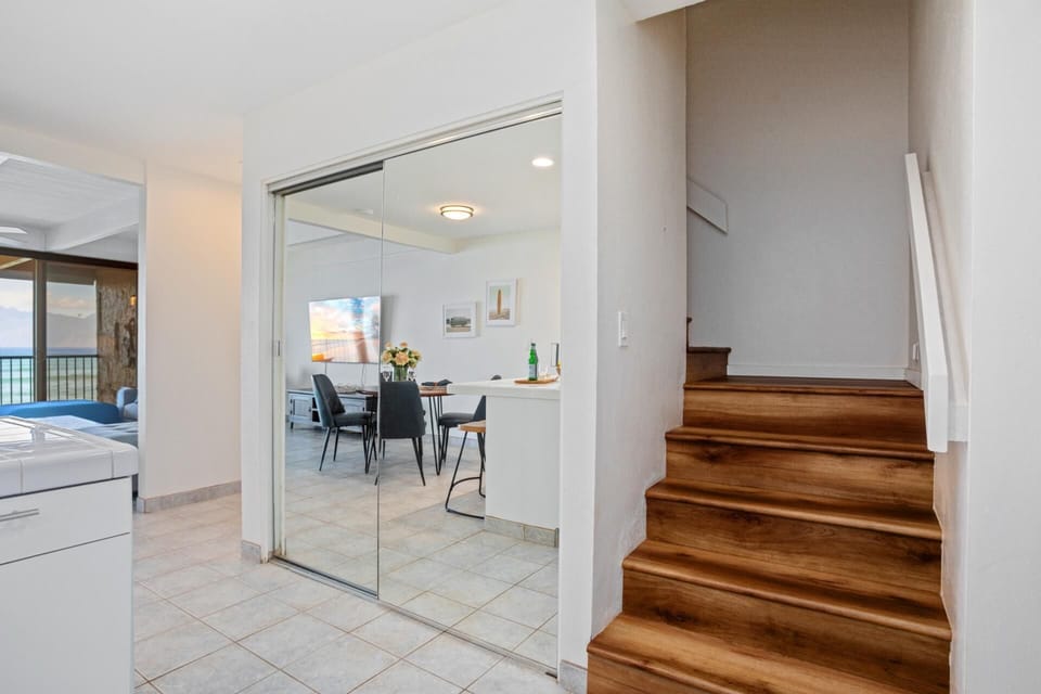 Tucked just beyond the kitchen, a warm wood staircase rises invitingly—promising cozy comforts and ocean-kissed dreams above LOK-B201
