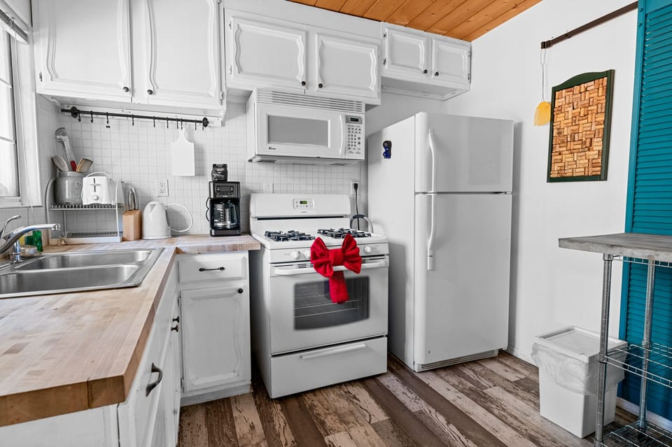 This cheery kitchen comes stocked with a microwave over, 4 burner stove & oven, standard brew drip coffee maker, toaster, refrigerator/freezer, dishes/utensils, pots/pans, blender & more