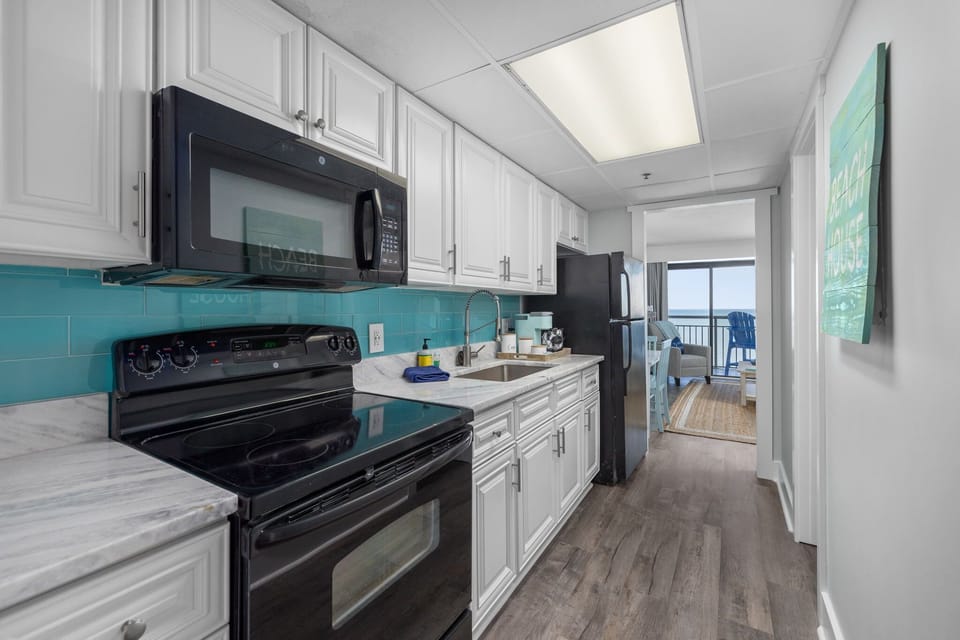 Full size kitchen appliances include stove, fridge, and microwave. . 