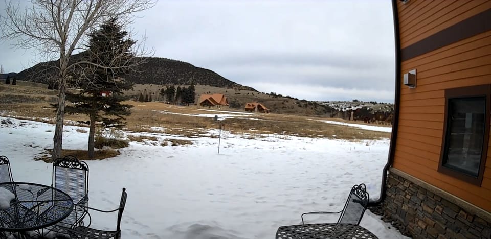 Back yard view of ninth green of Rio Grande Club, porch with seating, gas grill