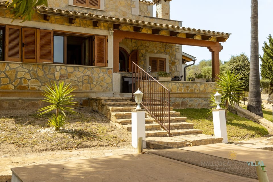 Main entrance to Villa Alejandra, an elegant Mallorcan-style villa featuring stone steps, covered terrace and a private garden.