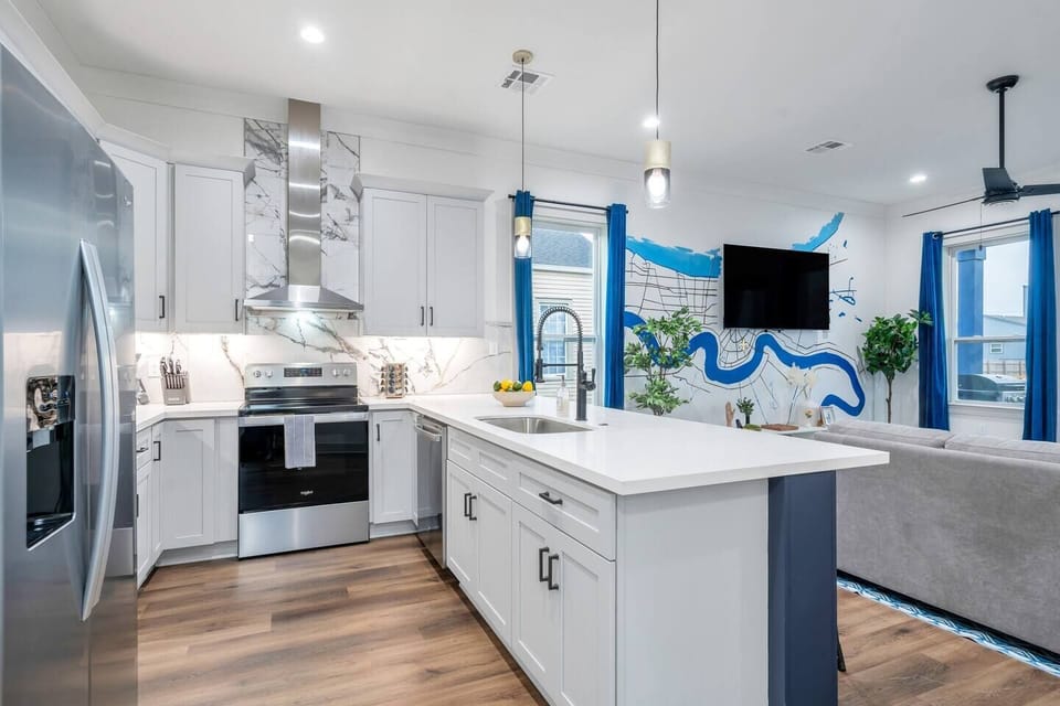 Kitchen view from the entryway showing clean white cabinetry & a center island.
