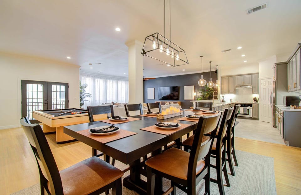 Featuring a sleek dark dinner table and matching chairs, the dining room’s decorative artwork and elegant table settings offer a restaurant-like environment for your meals.