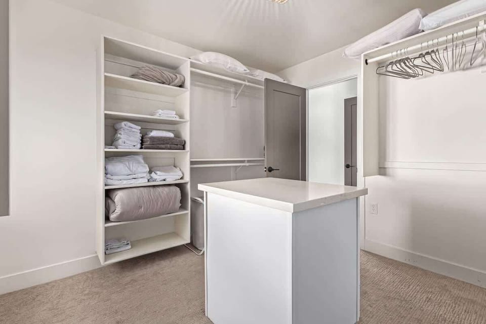 Primary bedroom with King bed, patio access, an en-suite walk-in shower with triple showerheads, soaking tub, and large walk-in closet space.