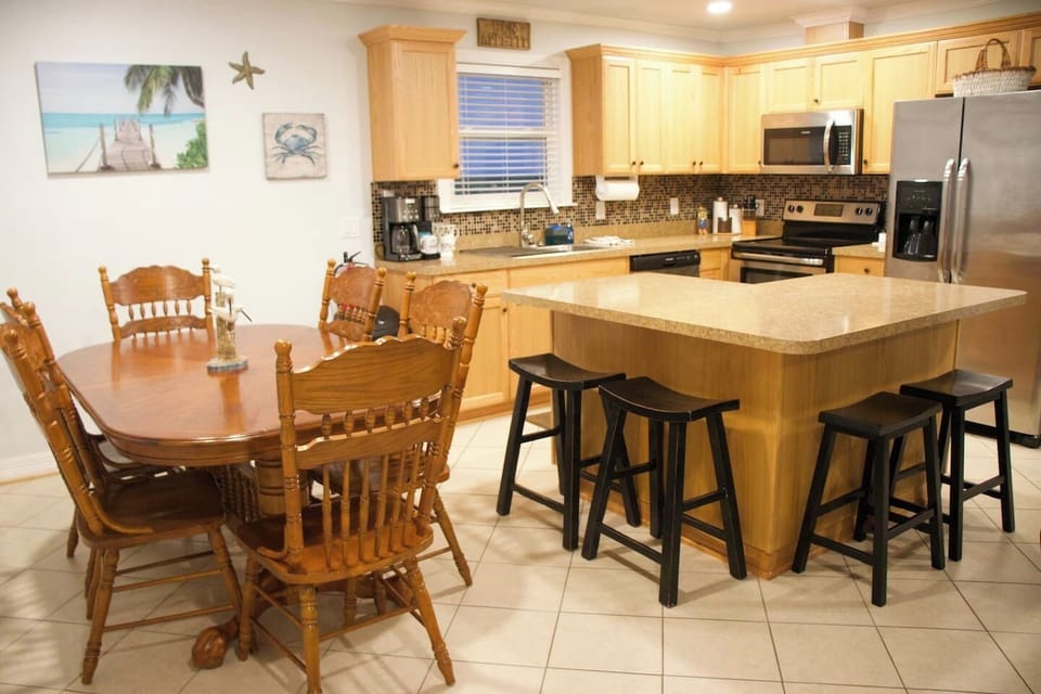 Table with seating for 6. Island to the right also has 4 bar stools for extra seating