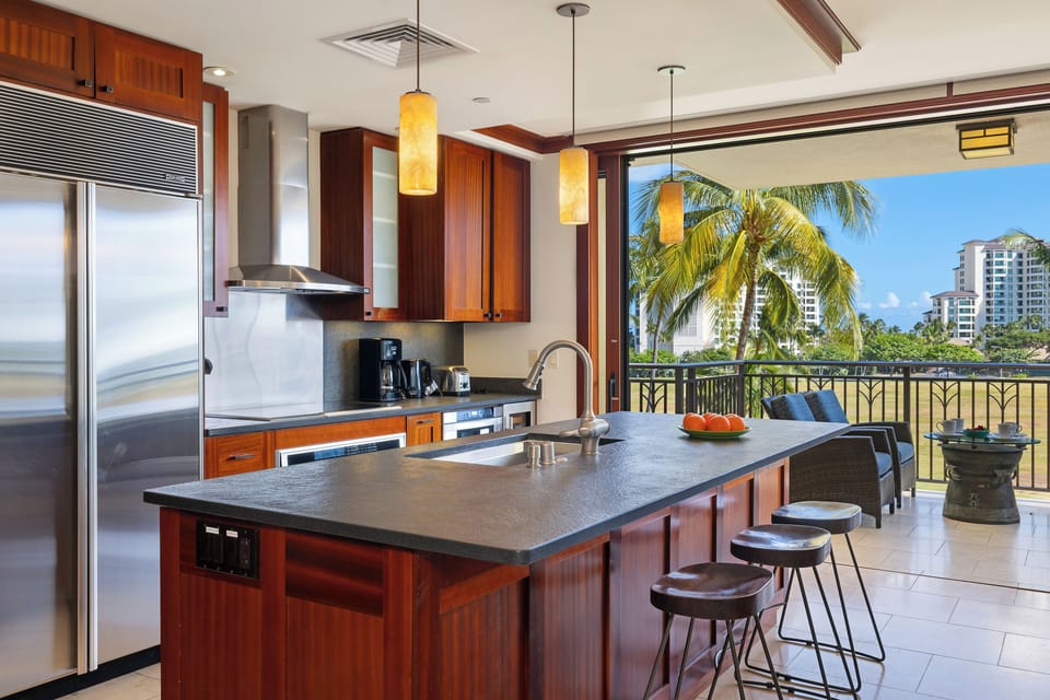 Your fully equipped kitchen opens to tropical views, perfect for preparing meals while enjoying palm trees and ocean breezes.