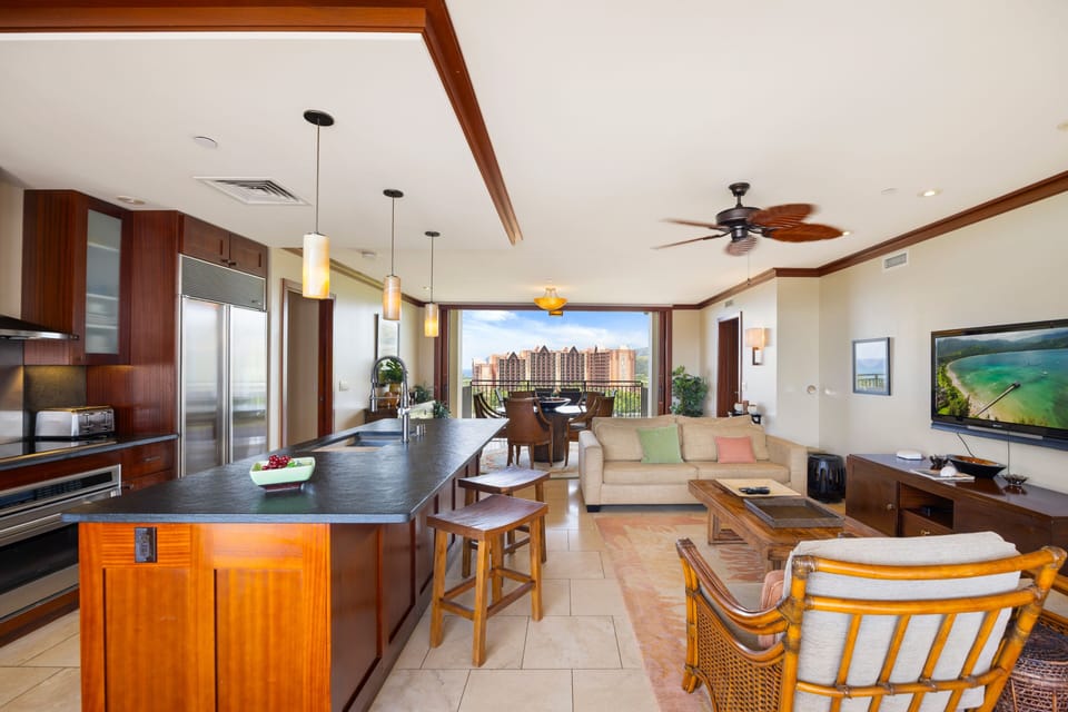 Your luxury island escape features an open kitchen, elegant dining space, and city views through floor-to-ceiling windows.