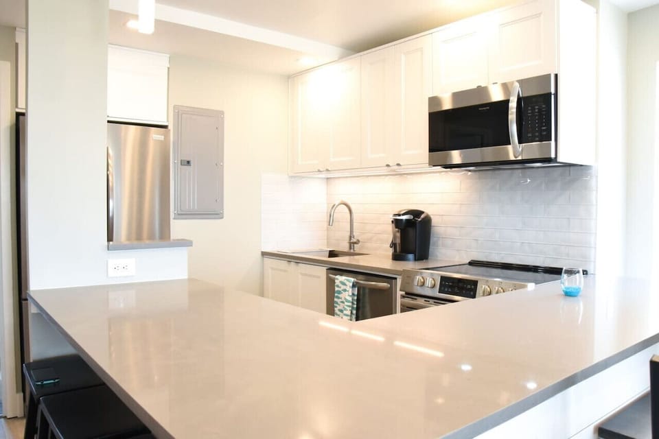 Bright, modern kitchen with quartz counters, stainless appliances, and plenty of space to cook and serve meals.