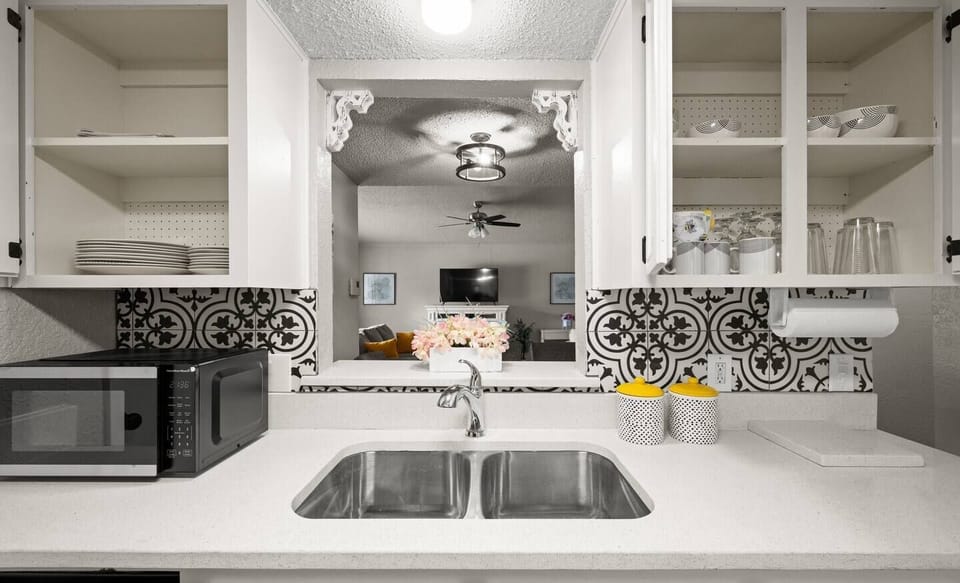 Elevate your culinary experience in this sophisticated kitchen. Stainless steel gleams, granite exudes luxury, and white cabinets amplify space. A corner sink with a modern faucet adds practical elegance. Cooking is a pleasure with these upscale amenities.