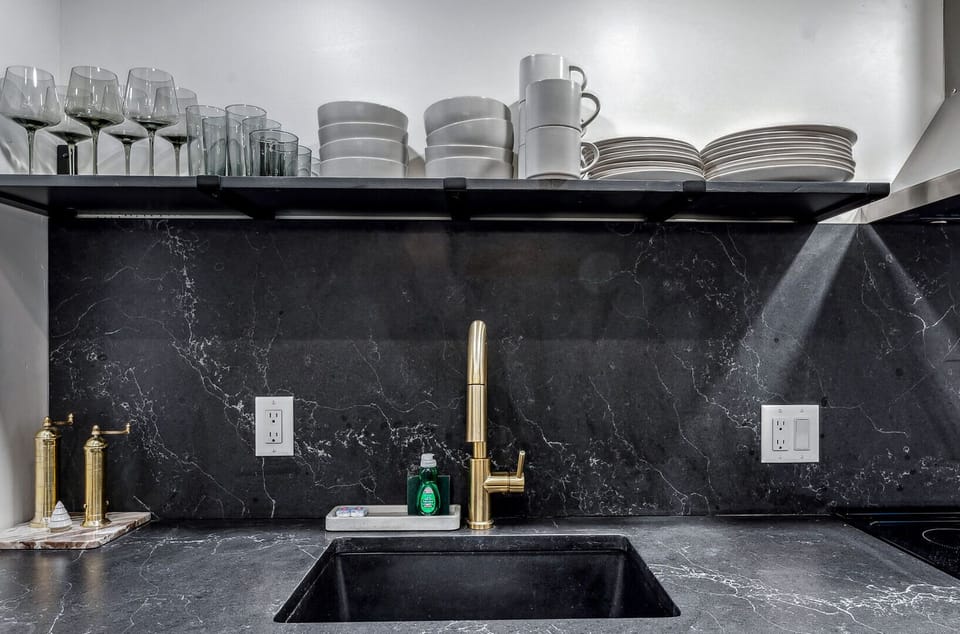 Kitchen with open shelving, wine glasses, and stainless range