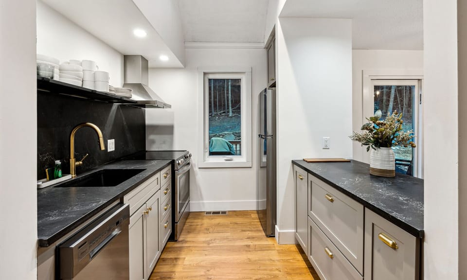 Galley kitchen with soapstone counters and gold hardware