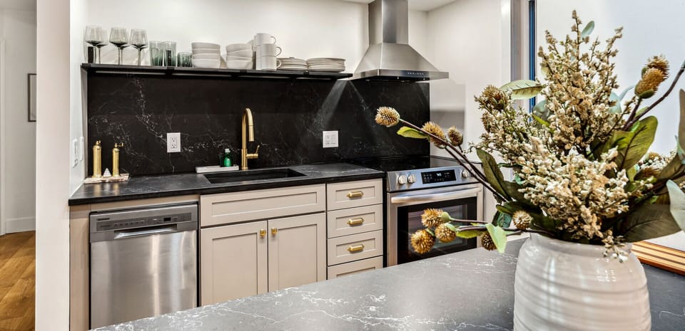 Renovated kitchen with soapstone counters, stainless appliances, and gold fixtures
