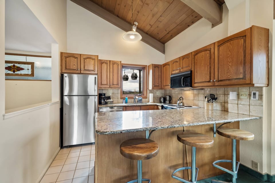 Breakfast bar and kitchen that has open sight lines through the main living area.