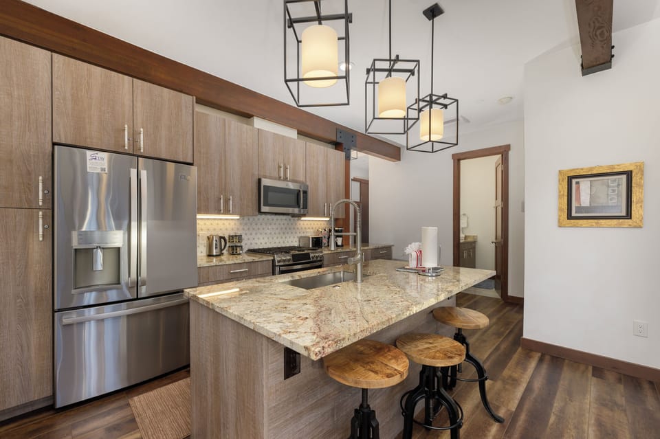 Your gourmet kitchen features granite counters, stainless appliances, and a breakfast bar perfect for morning coffee or casual meals.
